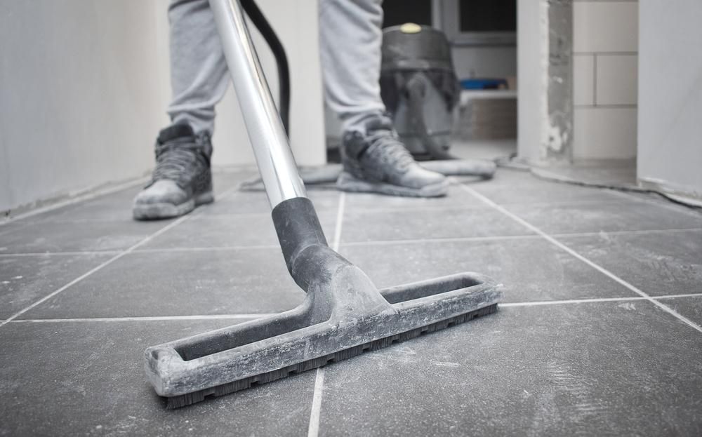 A Person is Using a Vacuum Cleaner to Clean a Tiled Floor — South Pacific Cleaning in Bentley Park, QLD
