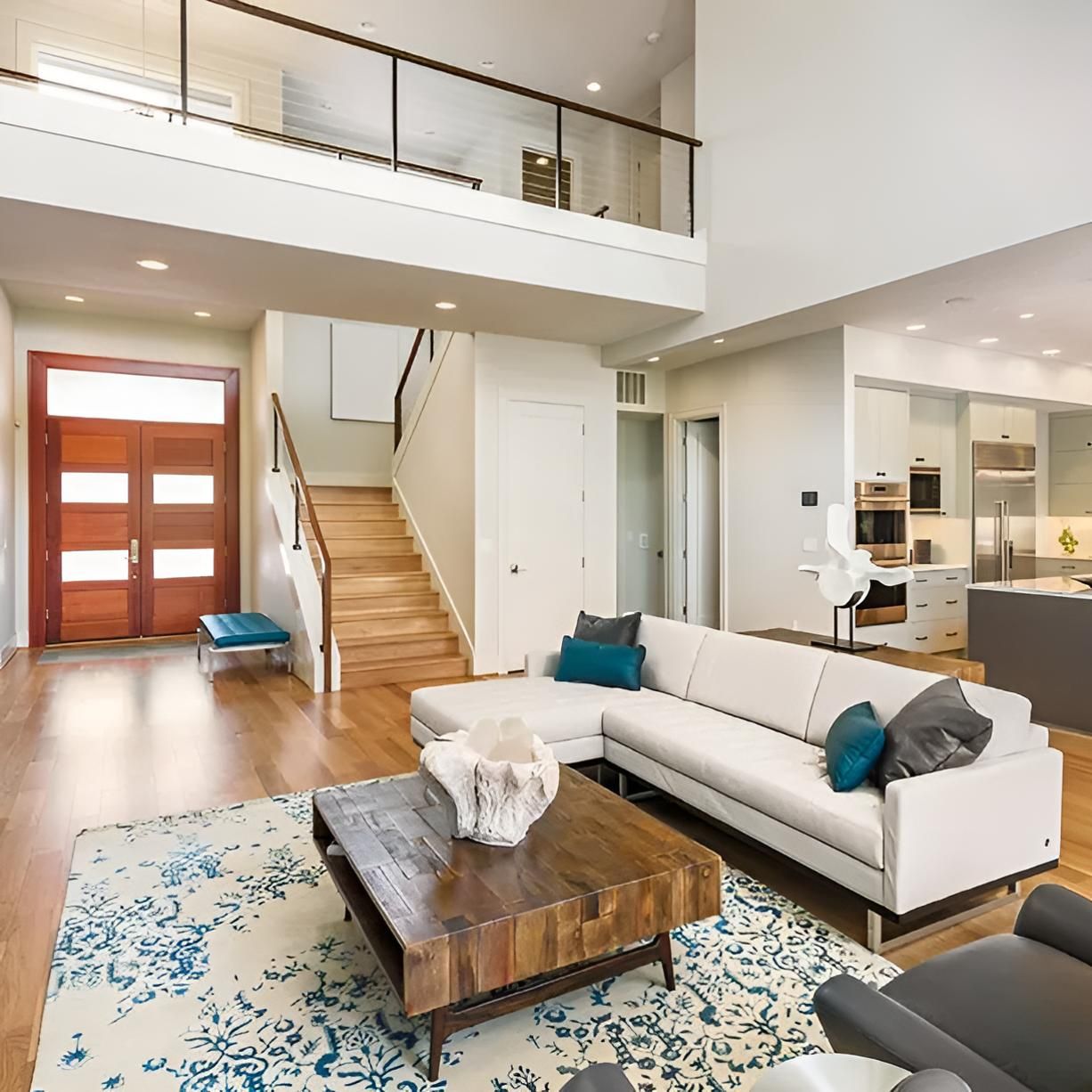 A Living Room With a Couch, Coffee Table and Stairs — South Pacific Cleaning in Bentley Park, QLD