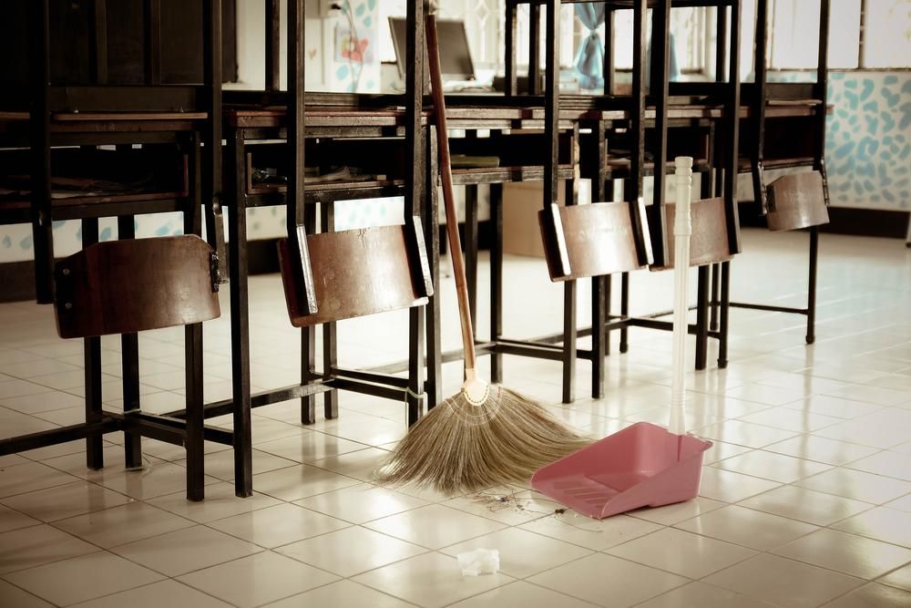 A Broom and Dustpan Are on the Floor in a Classroom — South Pacific Cleaning in Cairns City, QLD
