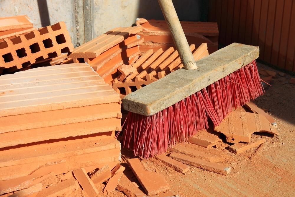 A Broom is Sitting on Top of a Pile of Brick — South Pacific Cleaning in Redlynch, QLD