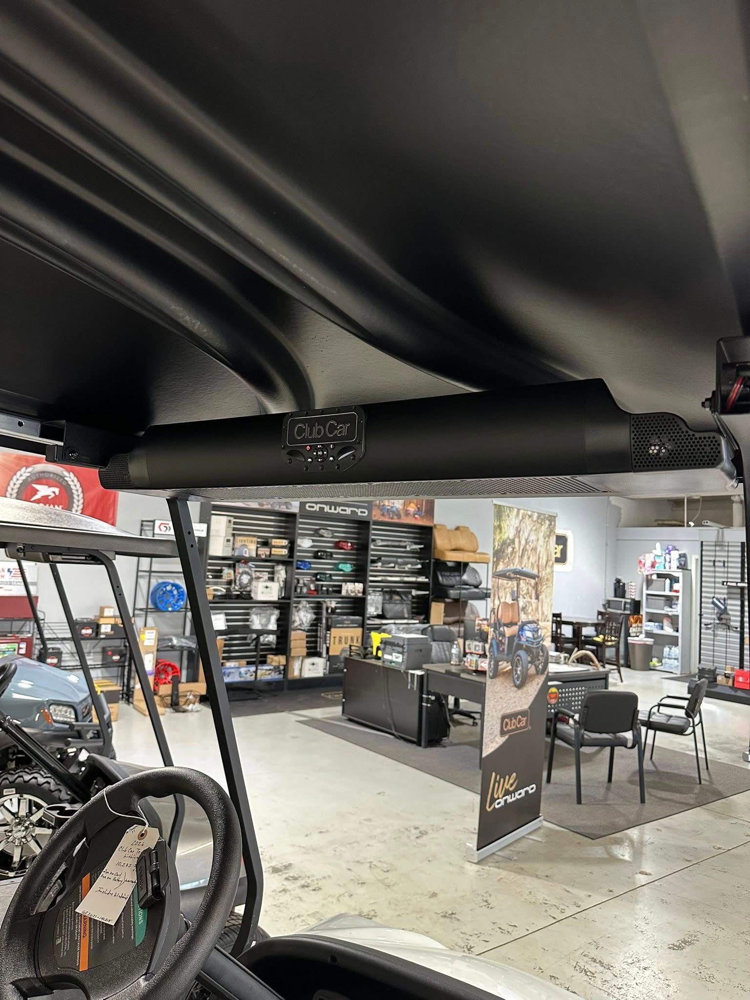 Golf cart interior with a black sound bar mounted on the roof.