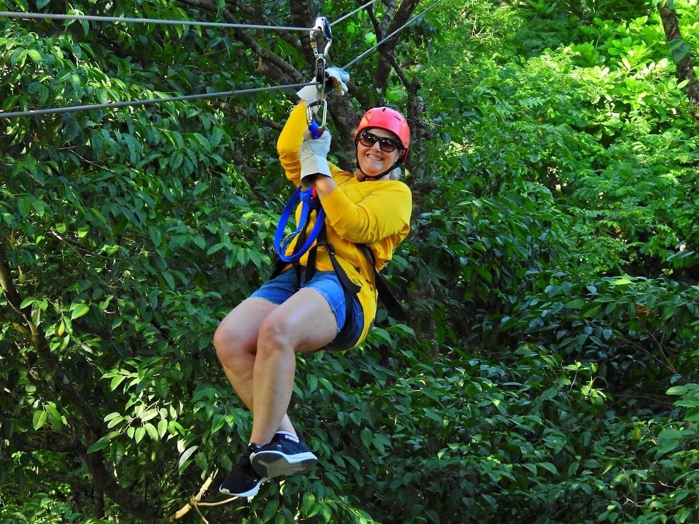A girl is climbing a canyon and a man is under her.