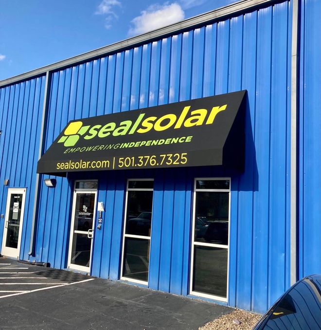 A blue building with a black awning that says sealsolar