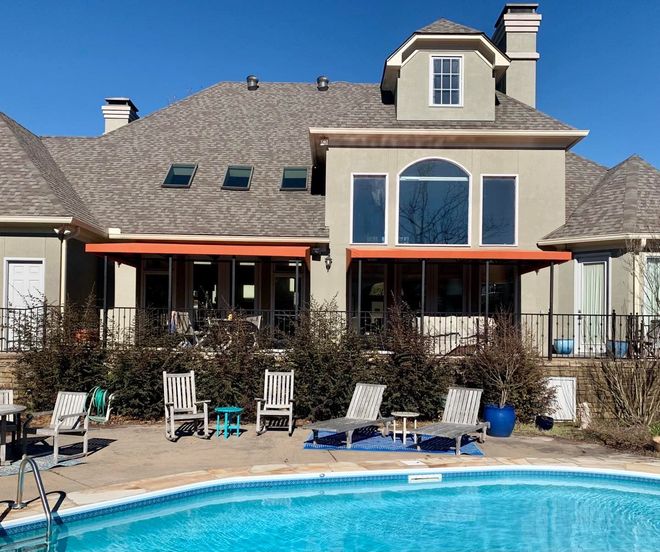 A large house with a swimming pool in front of it.