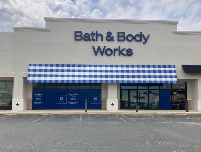 A bath and body works store with a blue and white checkered awning