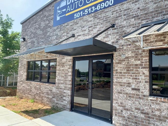 The front of a brick building with a canopy over the door.