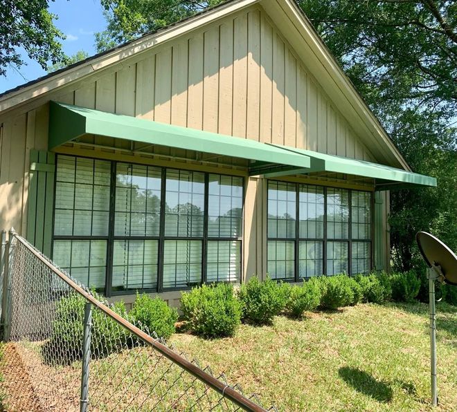 A house with a green awning over the windows