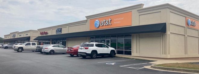 A row of cars are parked in front of a building.