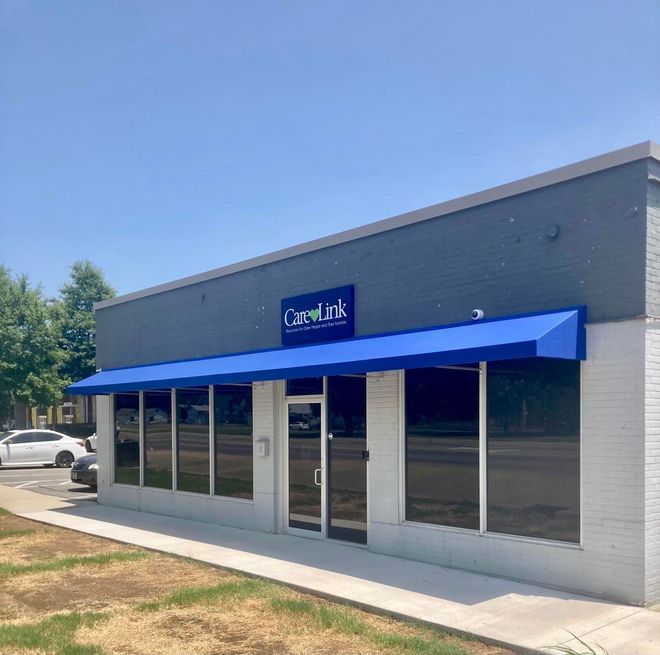 A building with a blue awning and a sign that says carelink