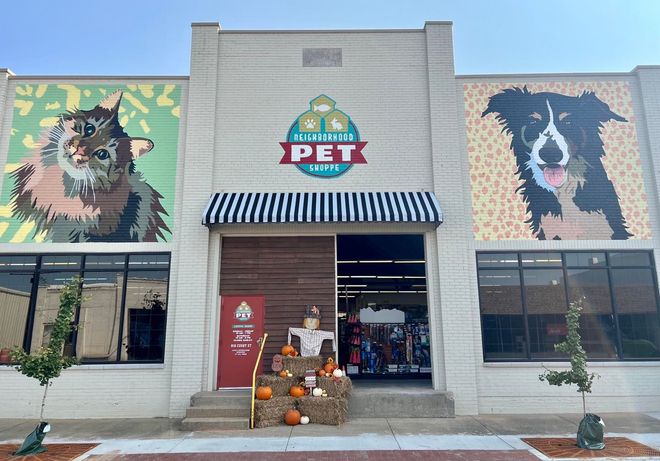 A dog and a cat are painted on the side of a building.