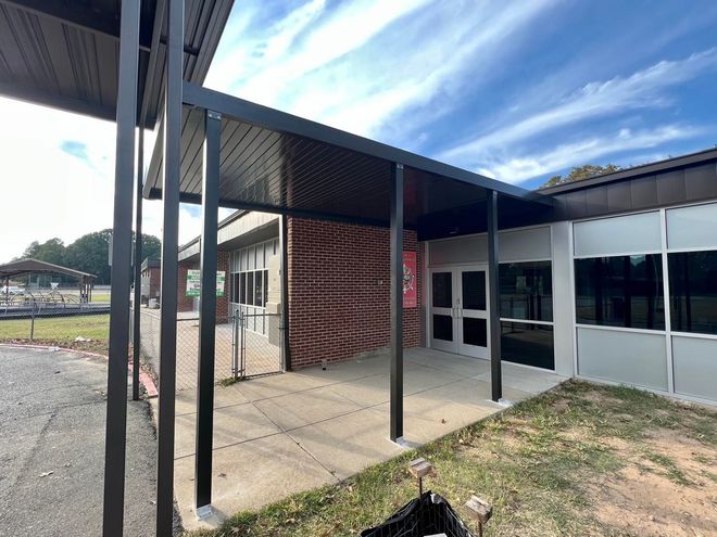 A large building with a covered walkway leading to it.