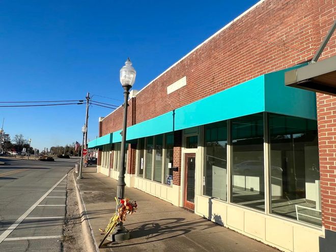 A brick building with a green awning on the side of it.