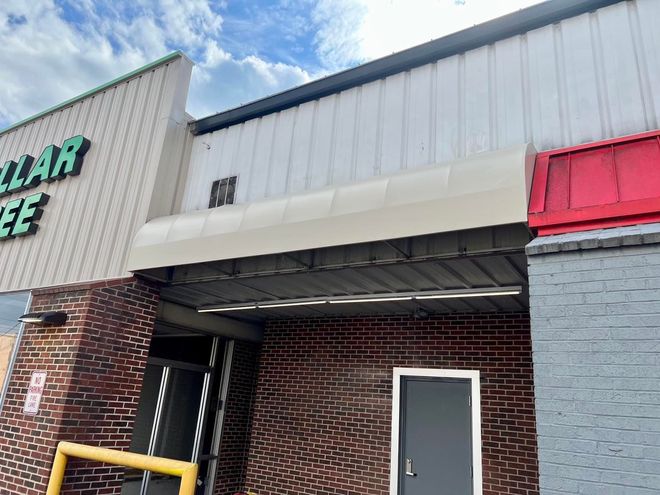 The front of a dollar tree store with a white awning over the door.