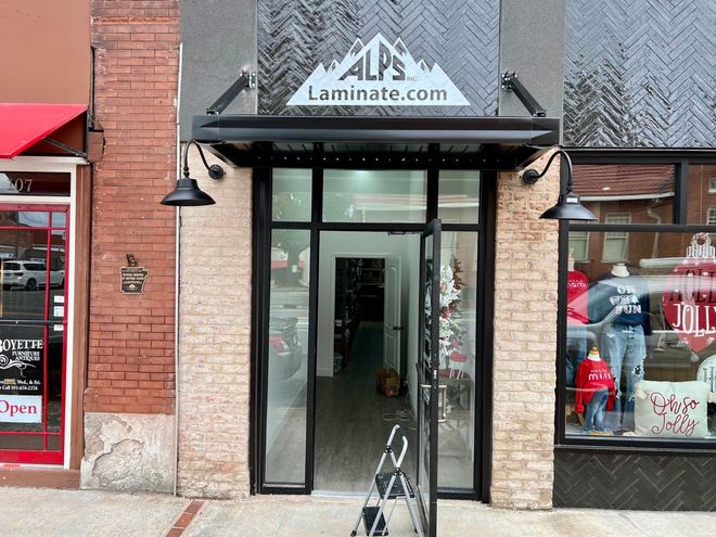 A store front with a sign that says alps laminate.com