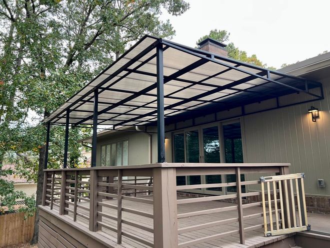 A deck with a canopy over it and a fence.