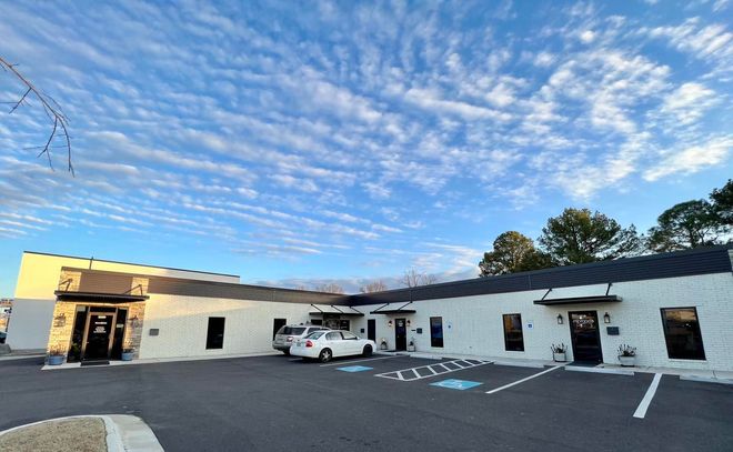 A white building with cars parked in front of it.
