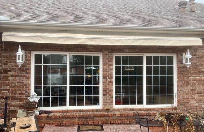 A brick house with a white awning over the windows.