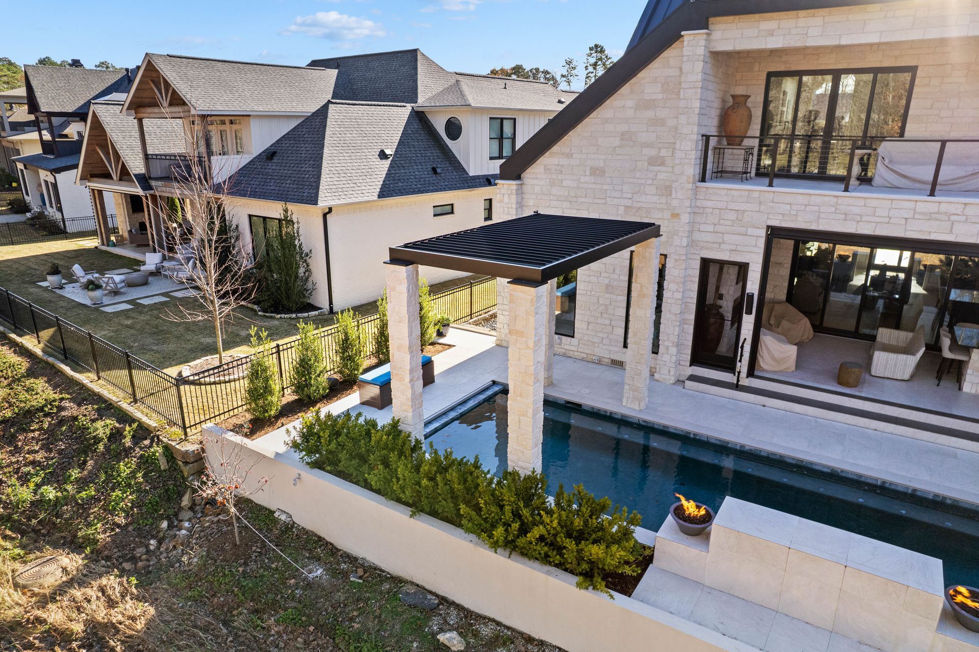 Modern house exterior with a pool, pergola, and landscaped backyard patio