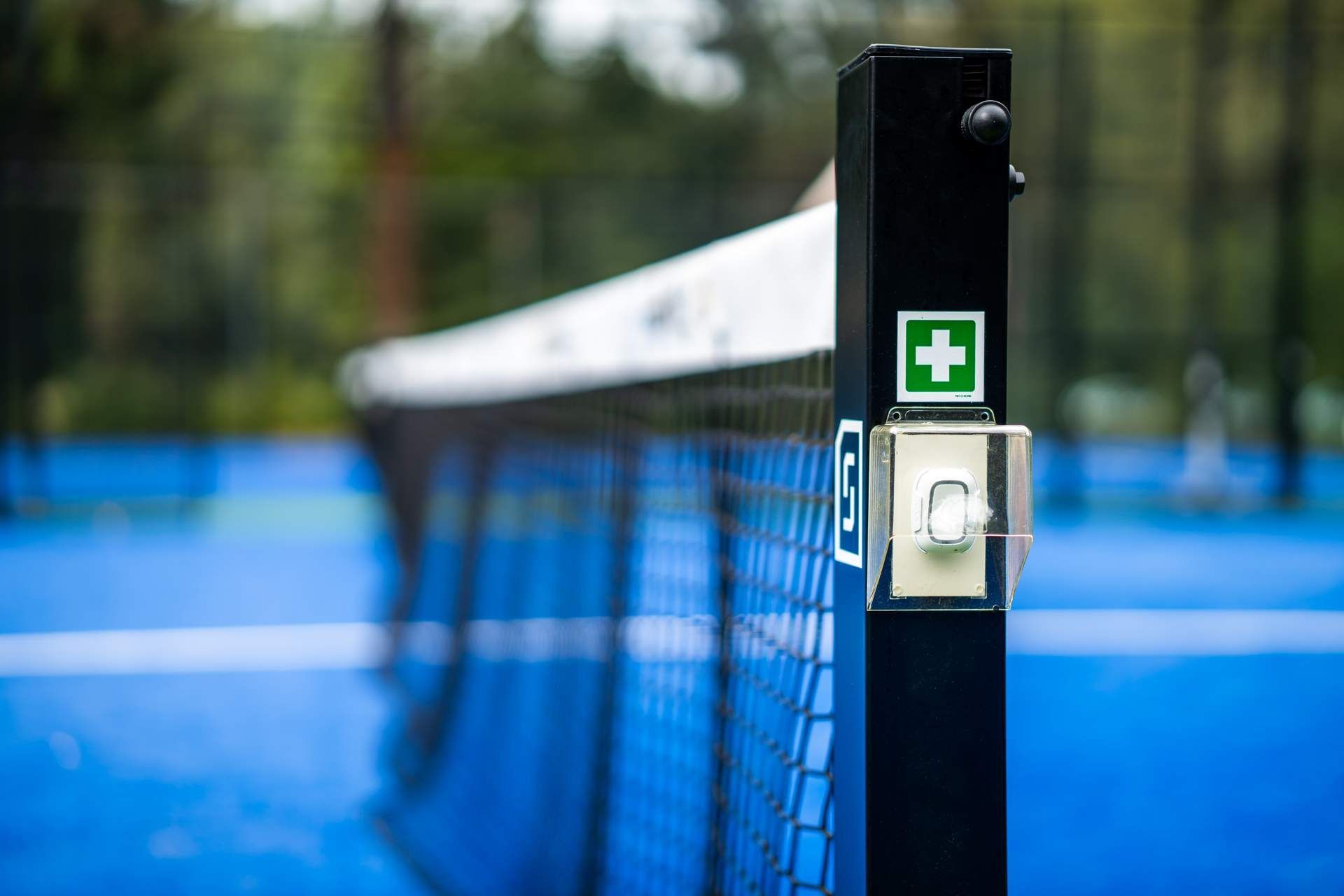 Een man ligt op zijn buik op een tennisbaan.