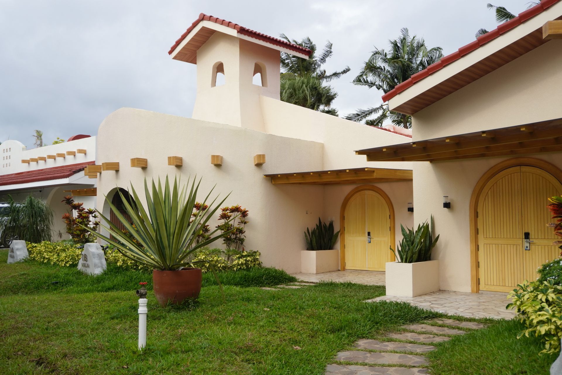 Costa Solana Family Beach Villa exterior with arched wooden doors and tropical l