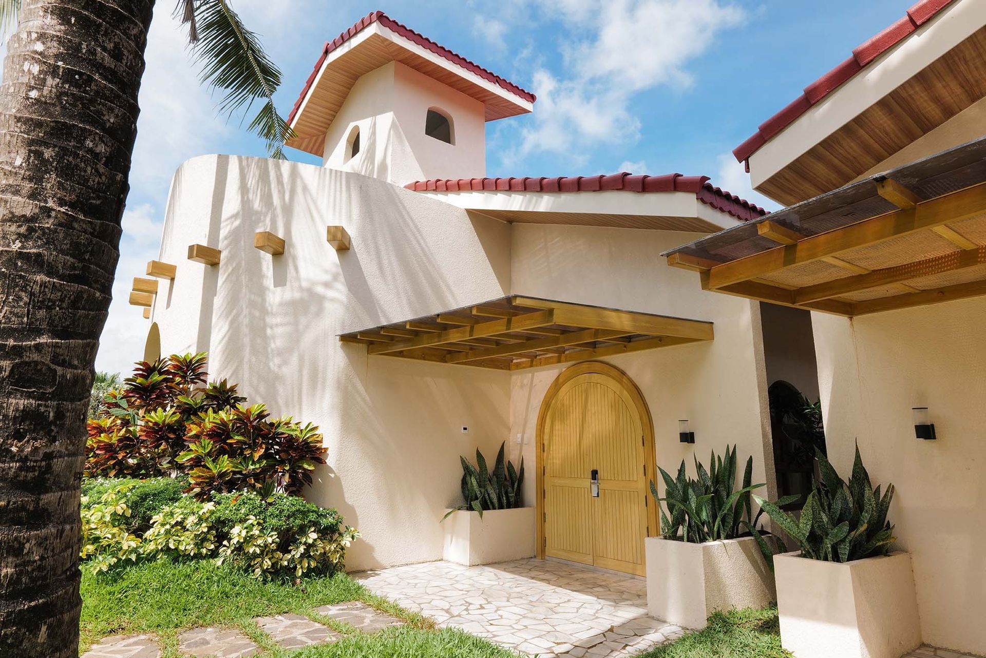 Family Beach Villa entrance with arched wooden door at Costa Solana Resort