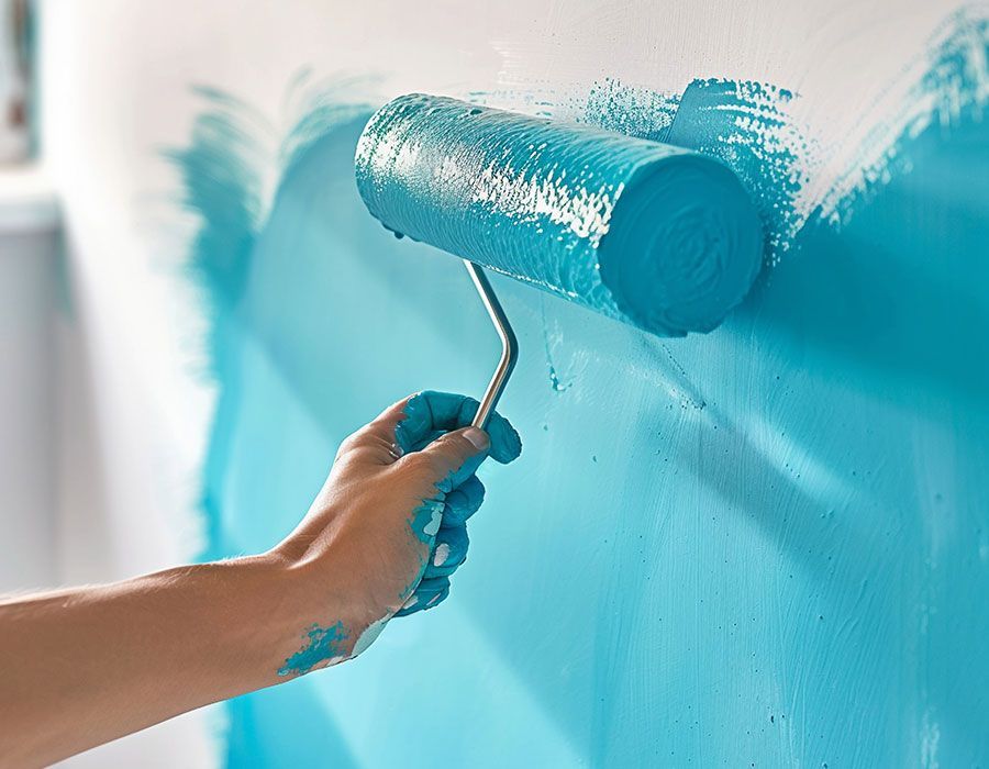 Hand painting a wall turquoise with a paint roller