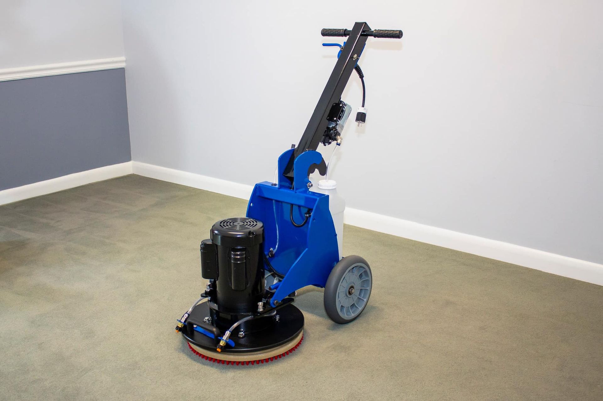 A blue machine is sitting on a carpet in a room.
