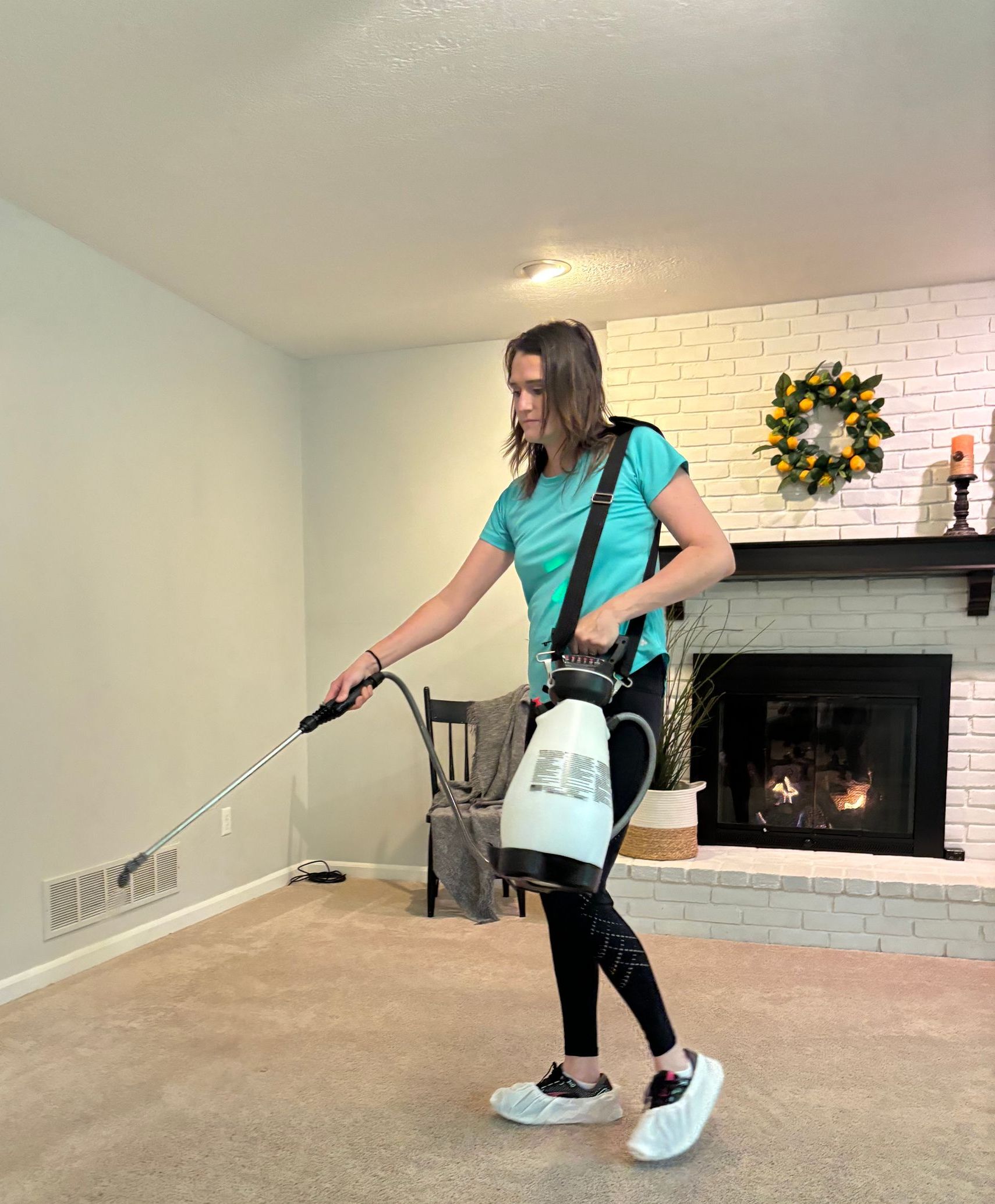 A woman is spraying a room with a spray bottle.