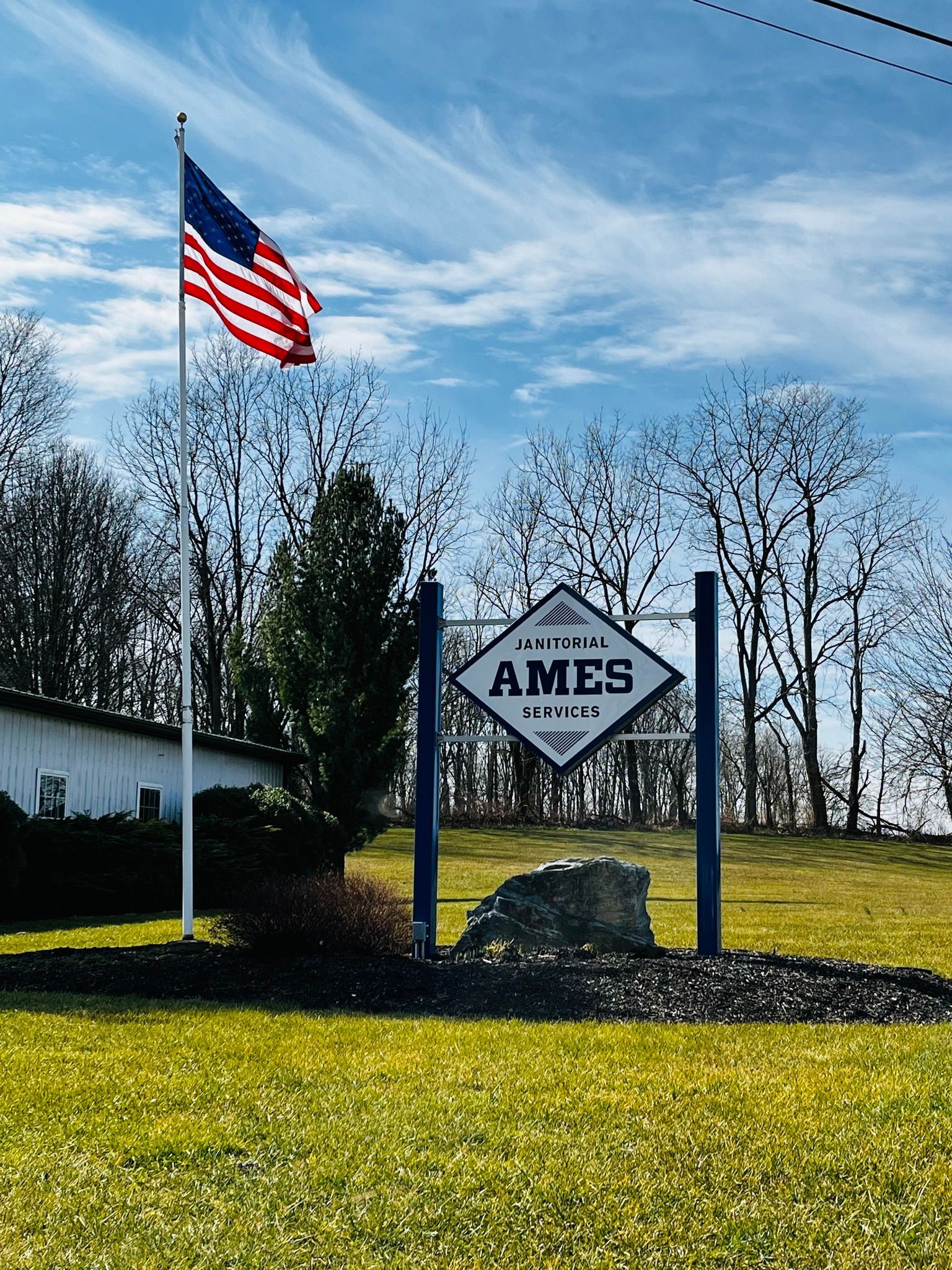 An american flag is flying in front of a sign that says ames