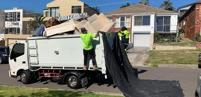 a red dumpster and a blue dumpster are sitting next to each other in a parking lot .