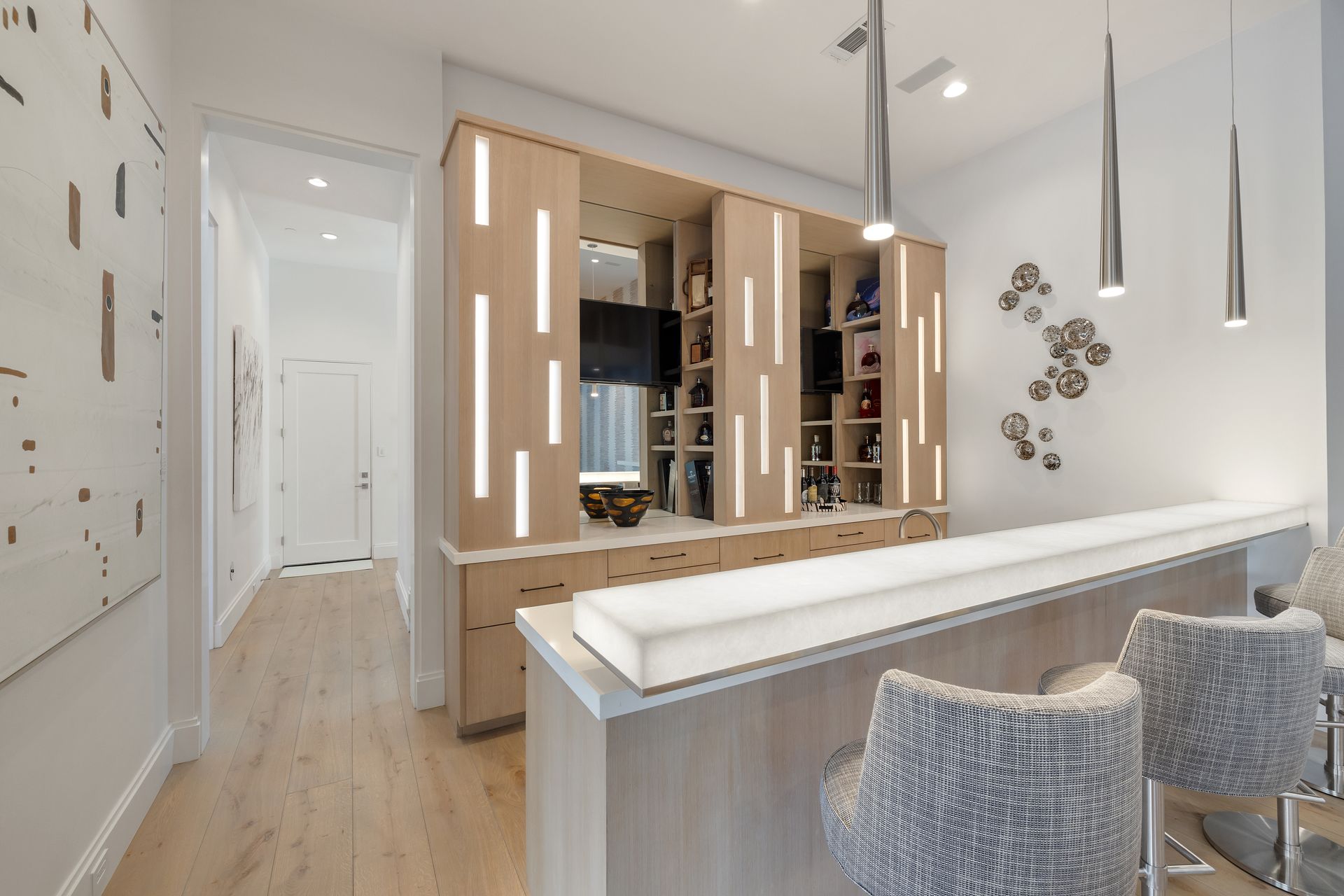 A room with a bar and chairs in it