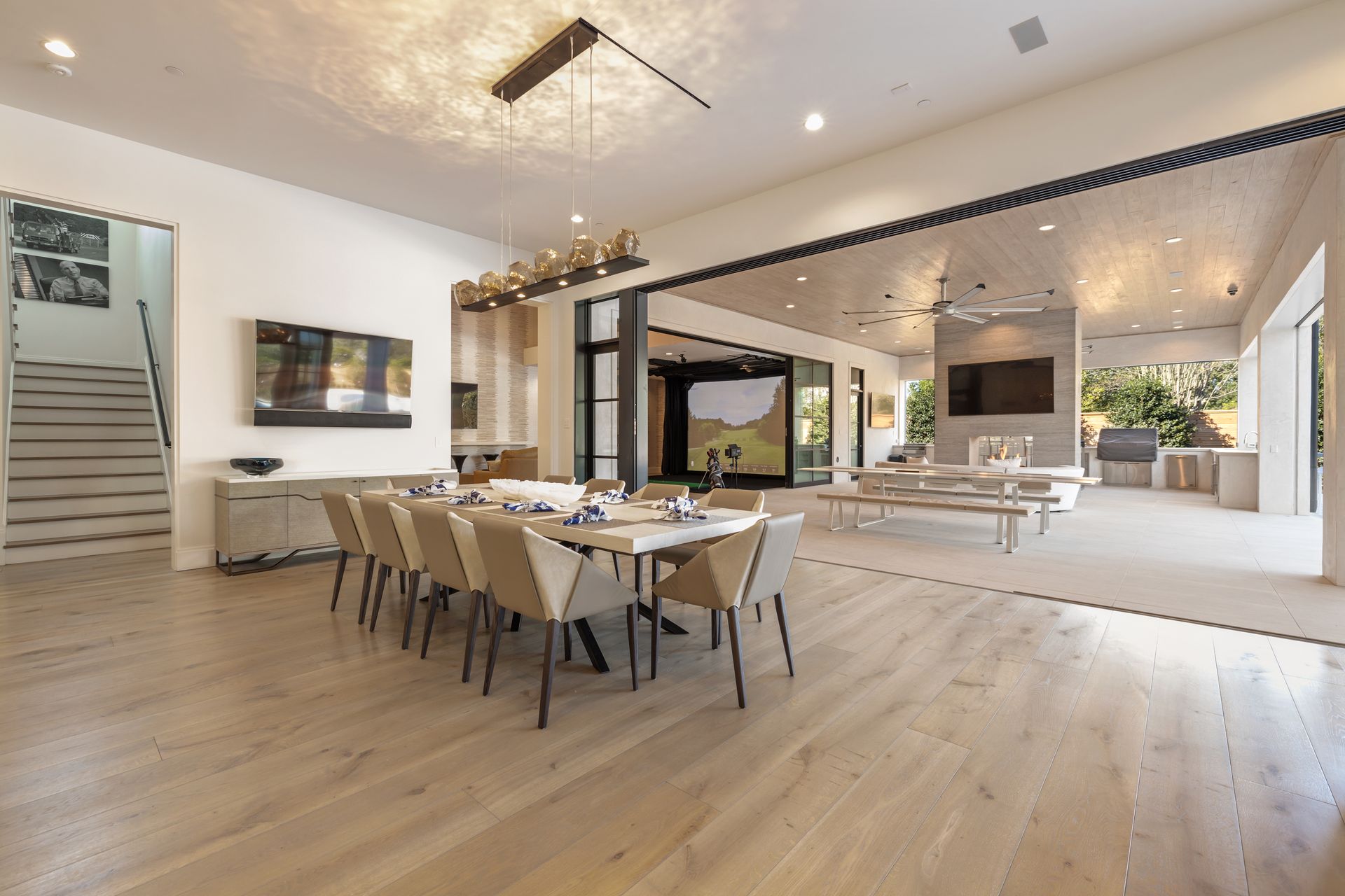 A large living room with a dining table and chairs and a flat screen tv.