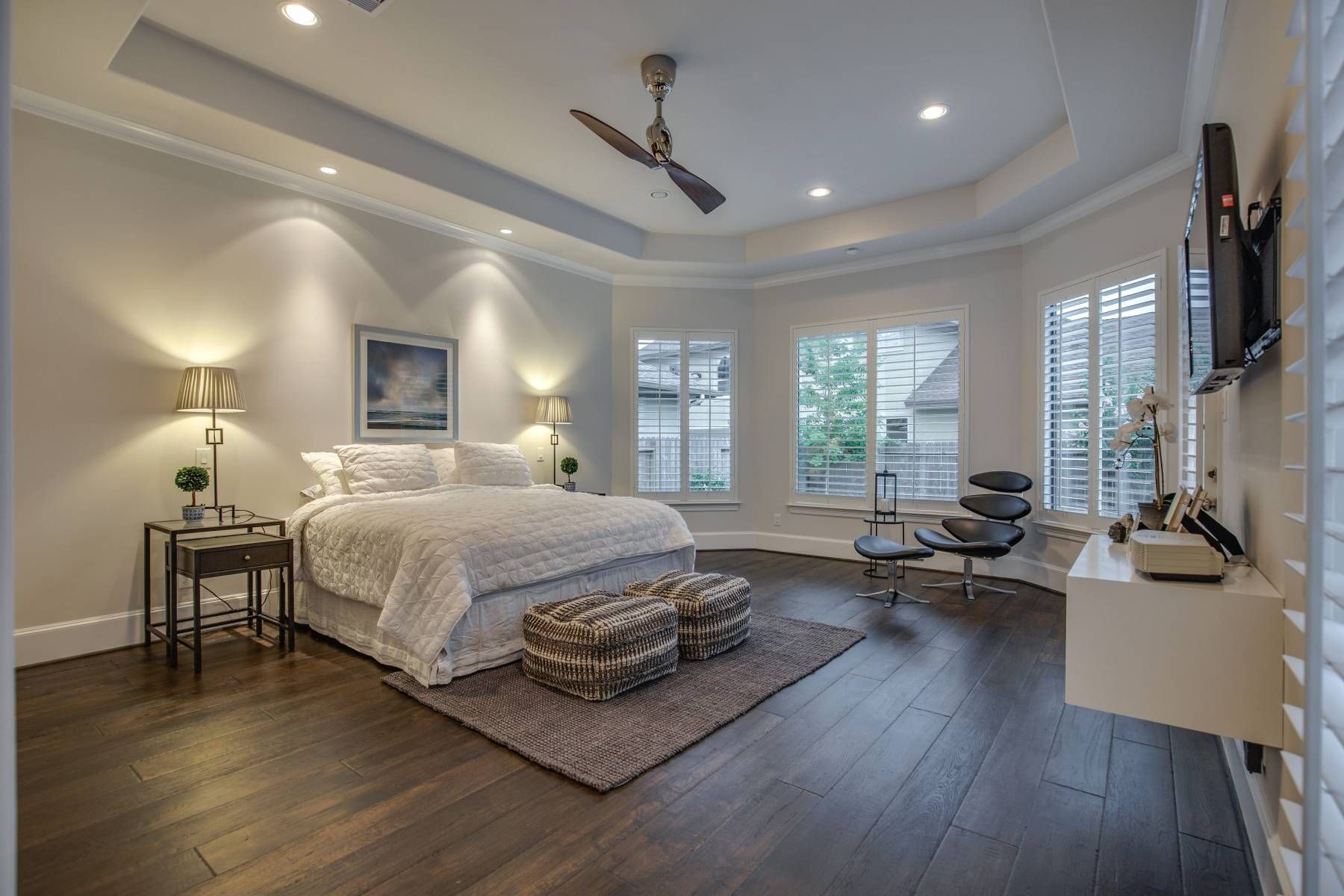 A large bedroom with a ceiling fan and a large bed.