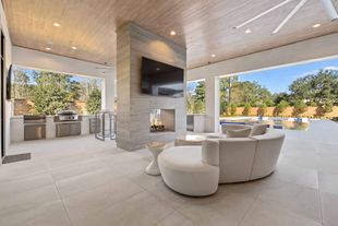 A living room with a couch and a television on the wall.