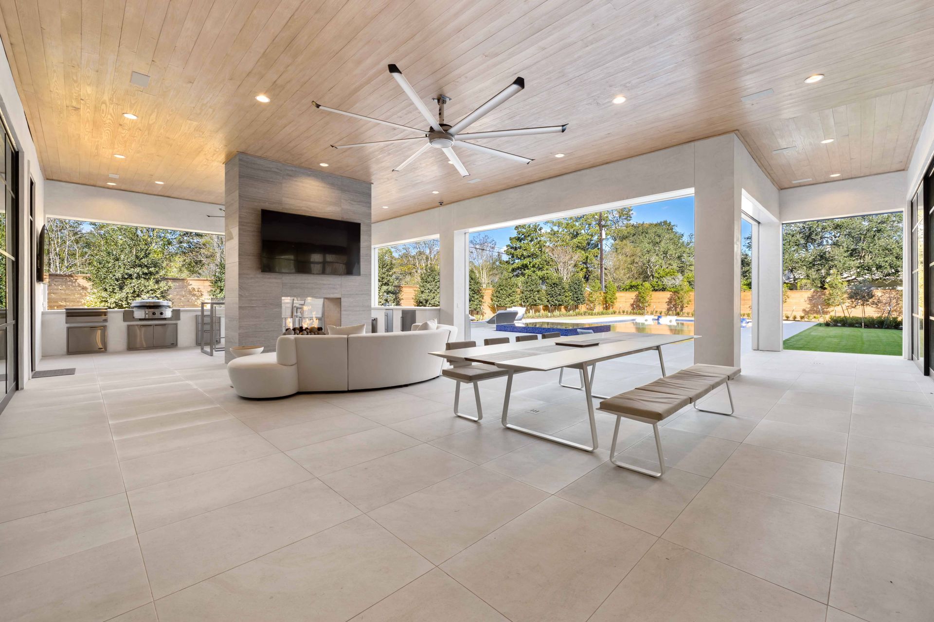 A living room with a table and benches and a ceiling fan.