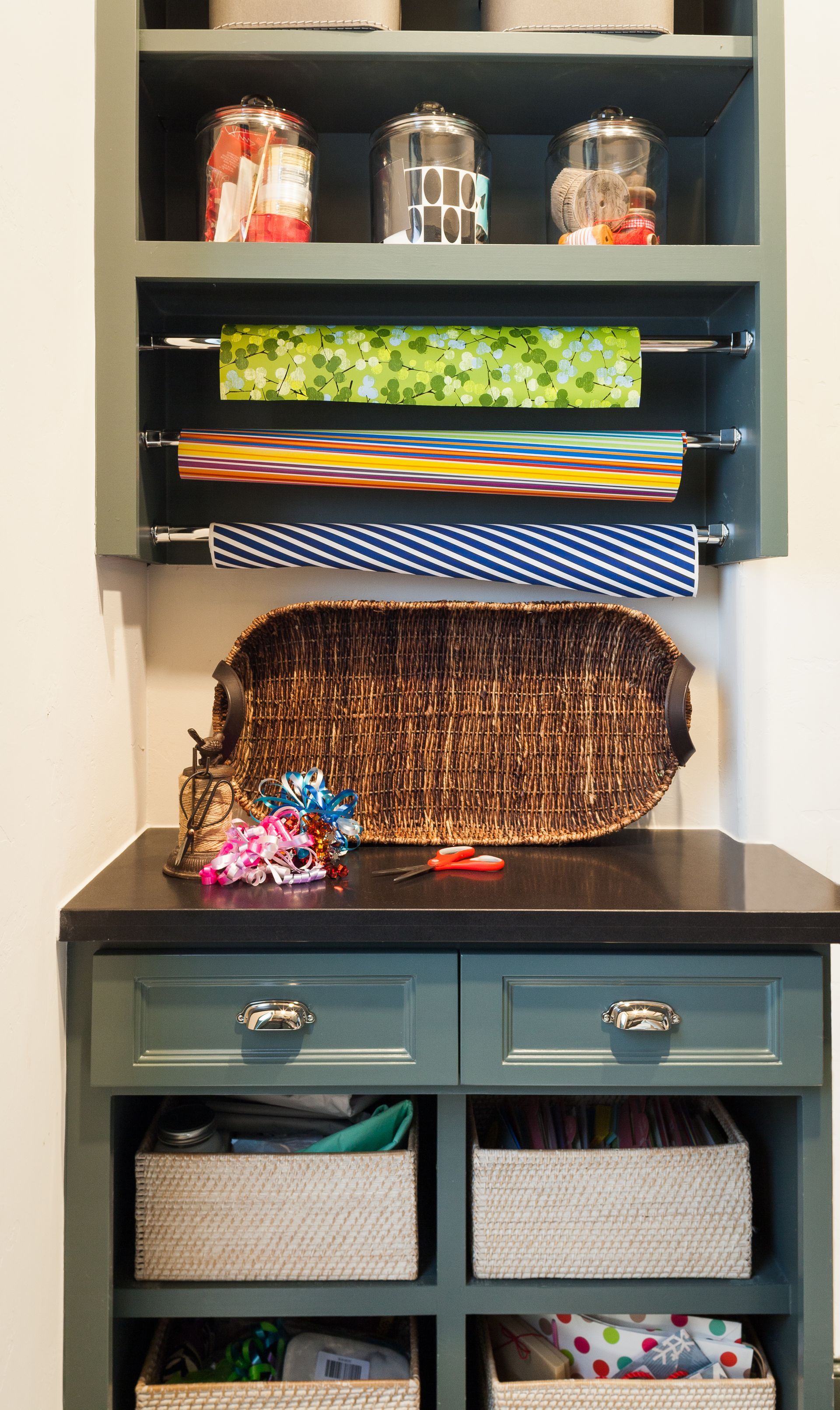 A shelf filled with lots of wrapping paper and baskets.
