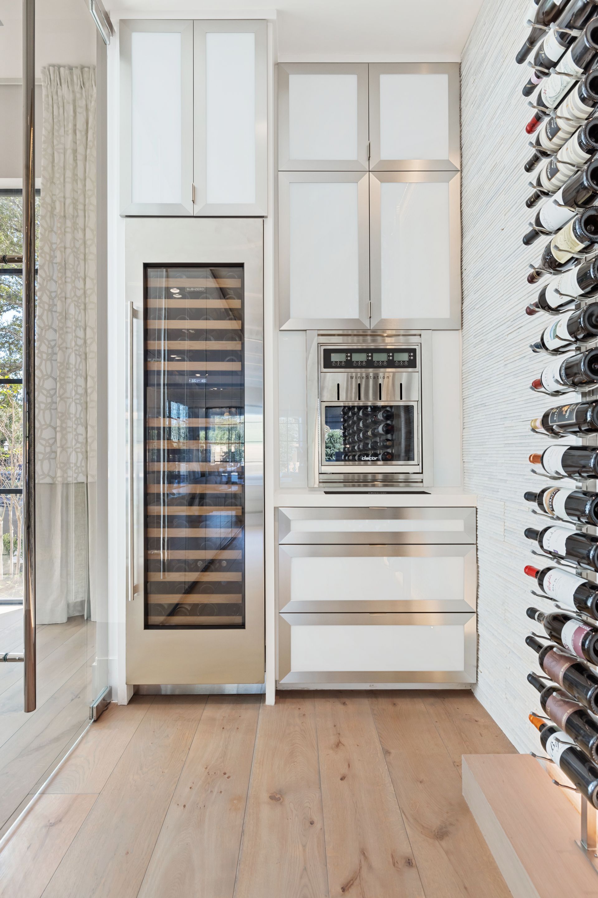 A kitchen with a wine cooler and a wine rack.