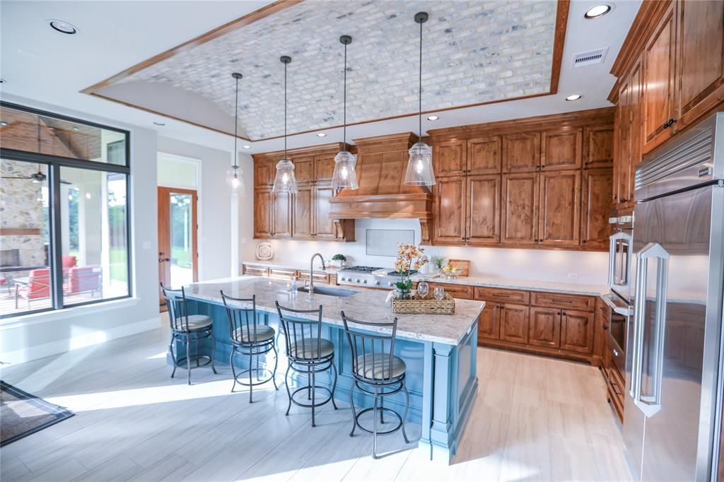 A kitchen with a large island and stainless steel appliances.