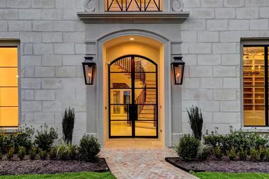 The front door of a large brick building with a walkway leading to it.