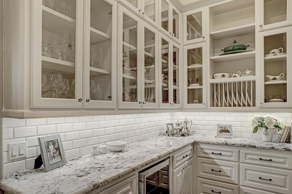 A kitchen with white cabinets and granite counter tops.