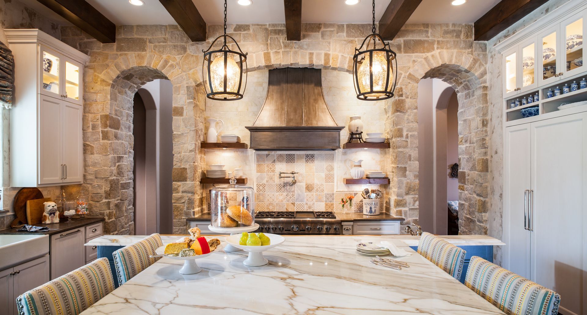 A kitchen with a large marble counter top and a stove.