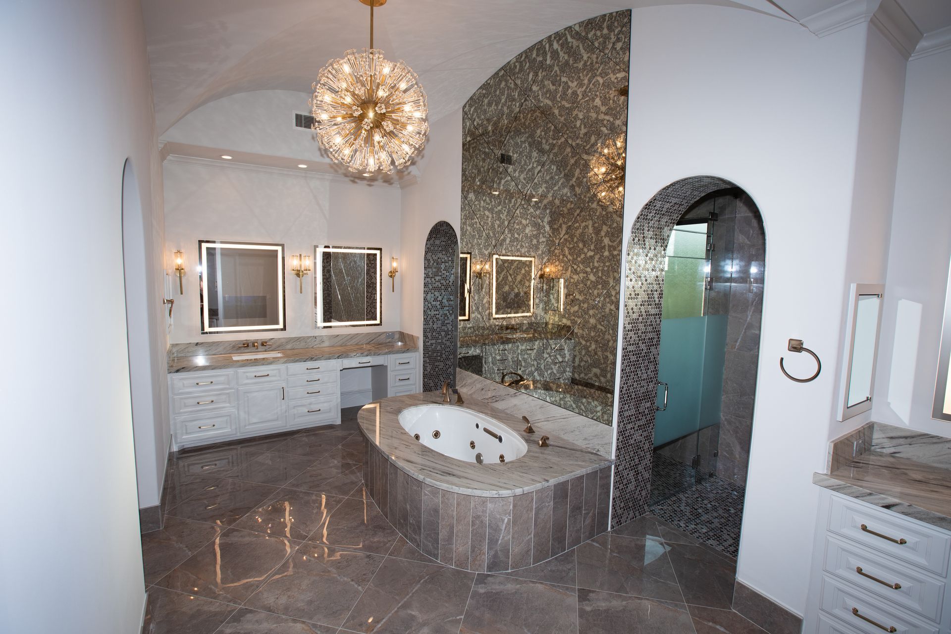 A bathroom with a large tub and two sinks.