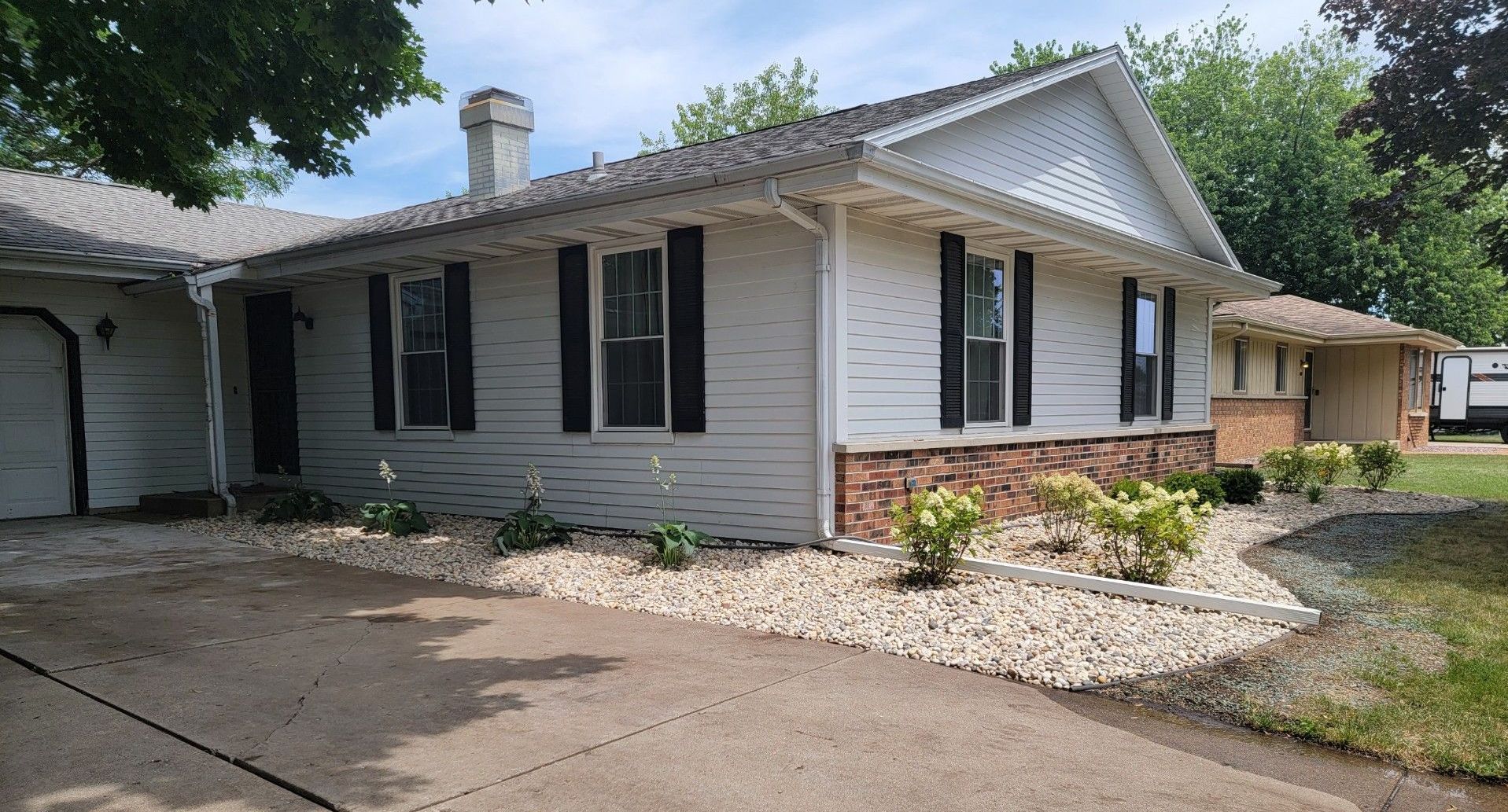 Landscaping and water runoff solution for while house with black shutters