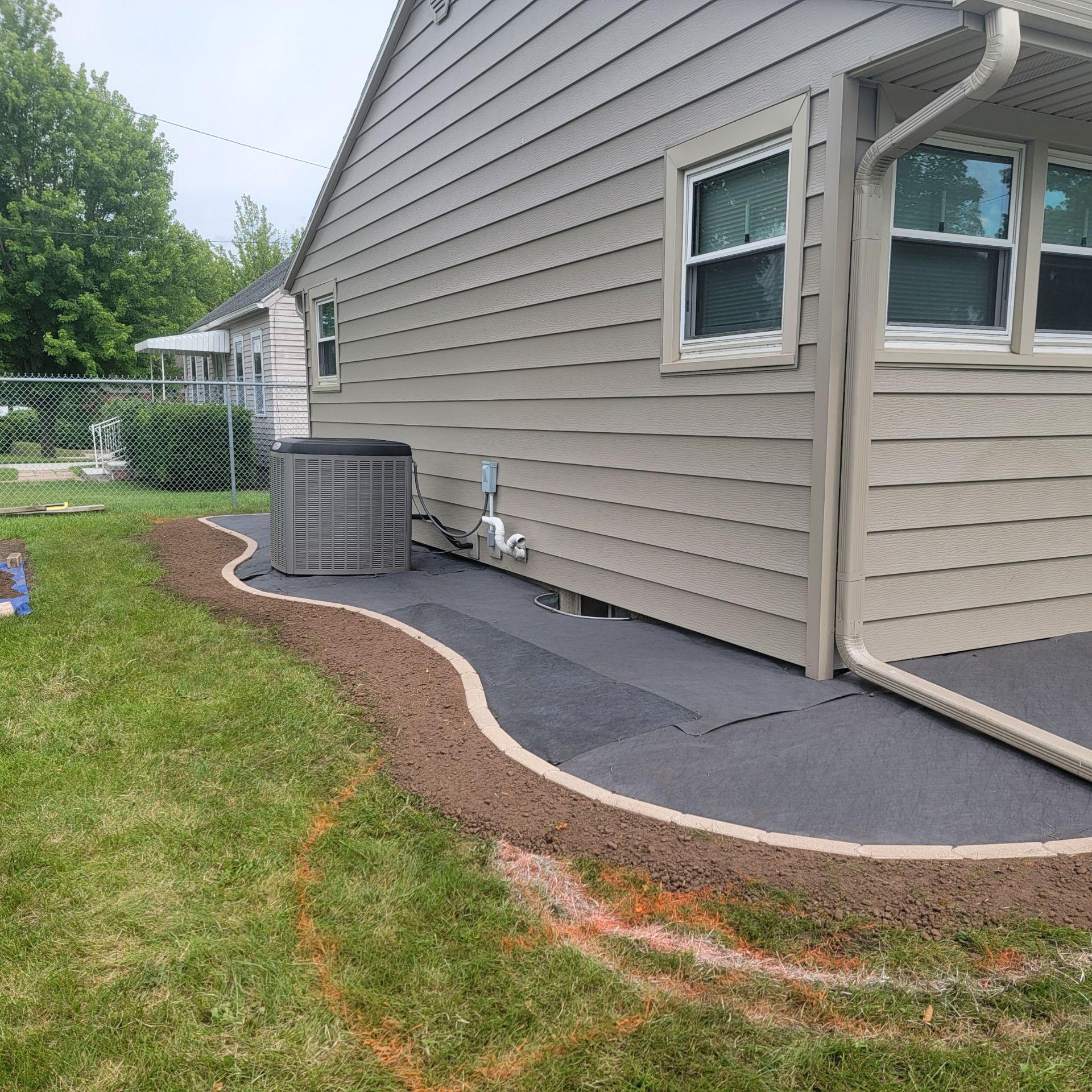 A house with a concrete curbing along flower bed edging