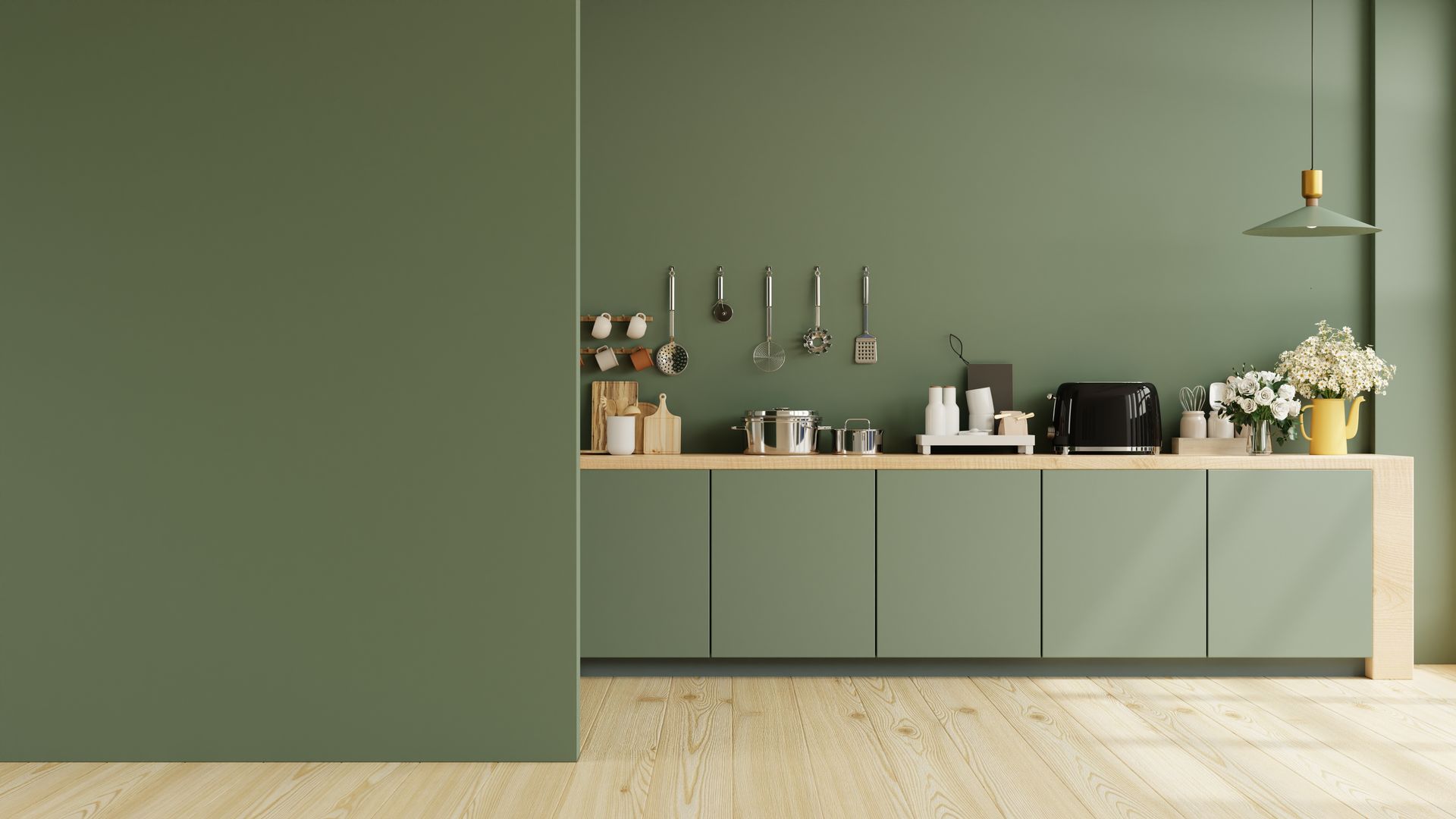 Minimalist green kitchen with cabinets, countertop appliances, hanging utensils, and flowers