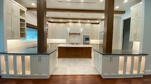 Bright modern kitchen with white cabinets, wood beams, and a central island.