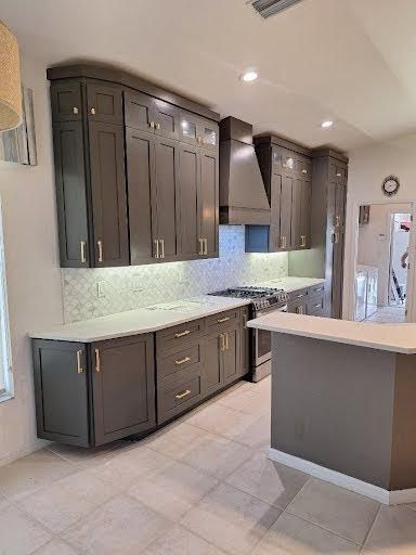 Modern kitchen with dark wood cabinets, light countertops, and a central island under recessed lighting