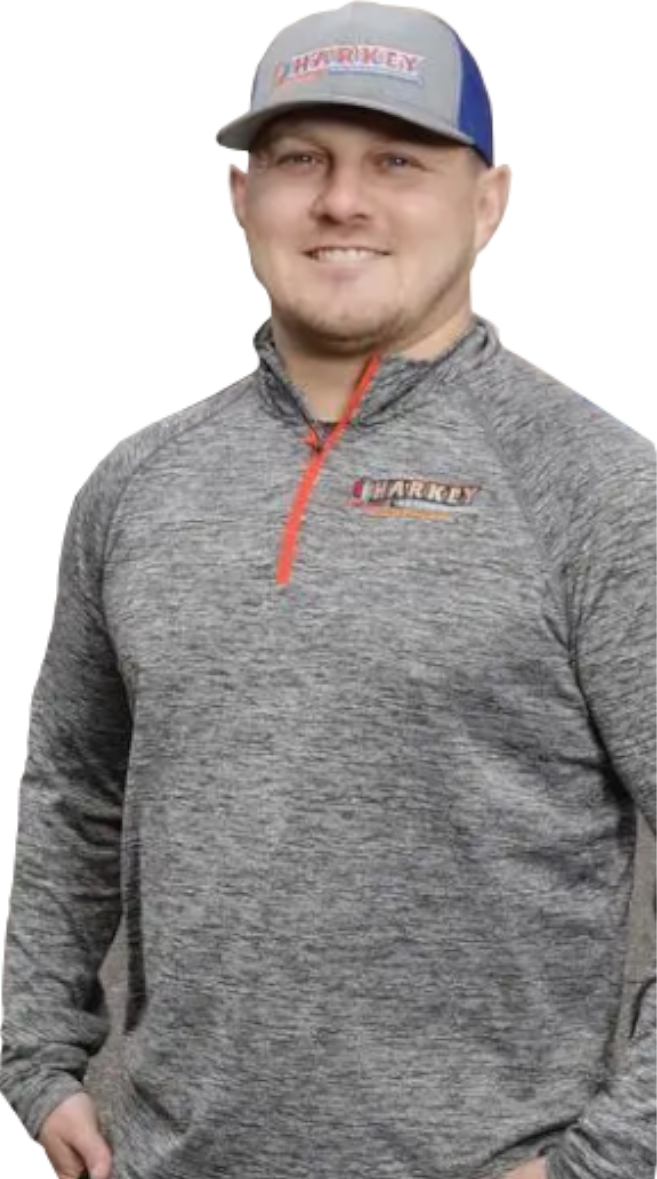 Man in gray and red logo cap and quarter-zip shirt, smiling.