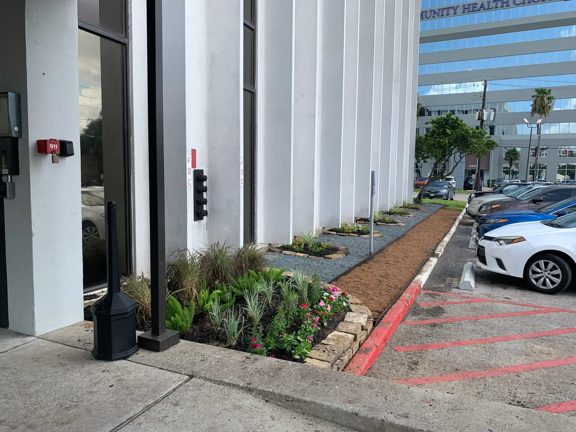 Accessible parking area beside a building with white columns, landscaping, and parked cars