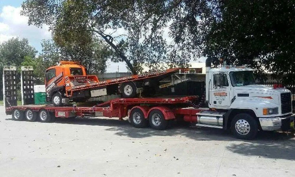 A Tow Truck Is Carrying a Flatbed Trailer with A Crane on It — Easylift Towing NSW Pty Ltd In Swansea, QLD